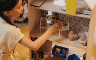 Kind spielt mit Puppenhaus