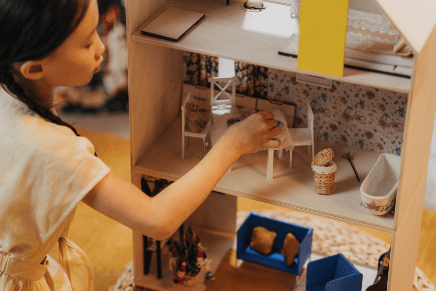 Kind spielt mit Puppenhaus